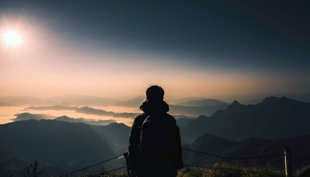 Man on a mountain looking at the horizon making choices and decision