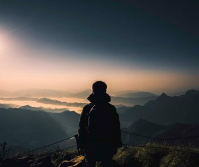 Man on a mountain looking at the horizon making choices and decision